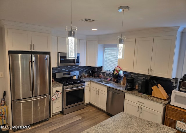 12 Togo Rd, Toms River, NJ 08757 - kitchen featuring stainless steel appliances, a sink, white cabinets, backsplash, and light stone countertops