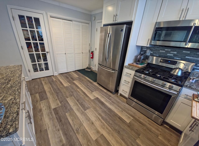 12 Togo Rd, Toms River, NJ 08757 - kitchen with appliances with stainless steel finishes, ornamental molding, dark wood-style floors, backsplash, and dark stone countertops