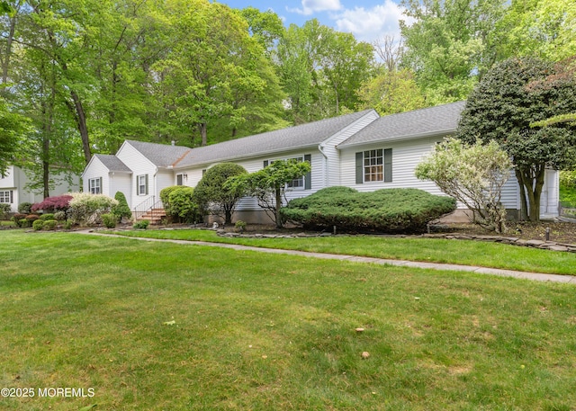 ranch-style home featuring a front yard and a shingled roof