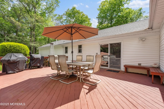 wooden deck featuring outdoor dining area and a grill