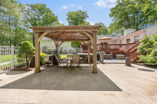 view of patio with a gazebo, outdoor dining area, fence, and a deck
