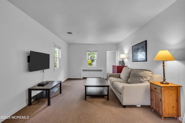 living room featuring radiator, light colored carpet, and baseboards
