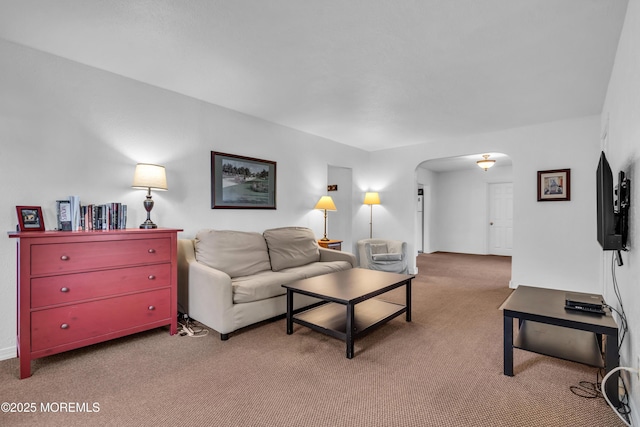 living area featuring arched walkways, carpet flooring, and baseboards