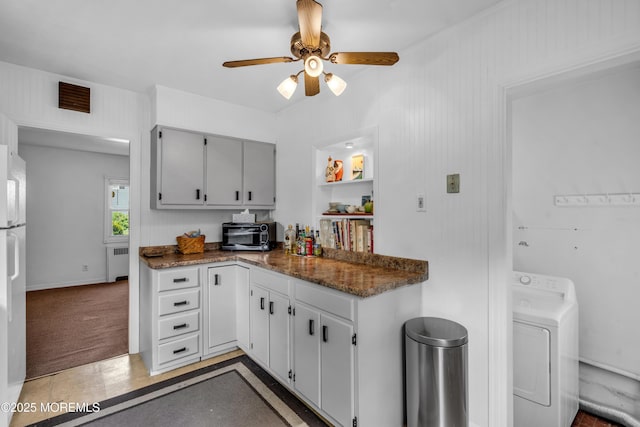 kitchen with washer / dryer, radiator heating unit, ceiling fan, gray cabinetry, and freestanding refrigerator