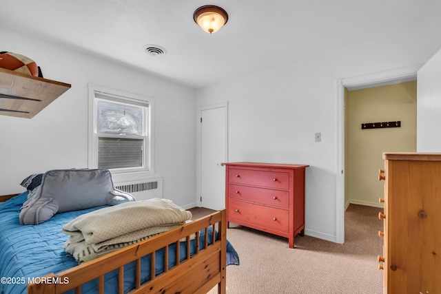 carpeted bedroom with radiator heating unit and baseboards