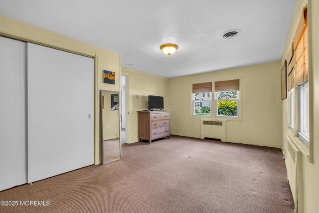 unfurnished bedroom featuring radiator and carpet