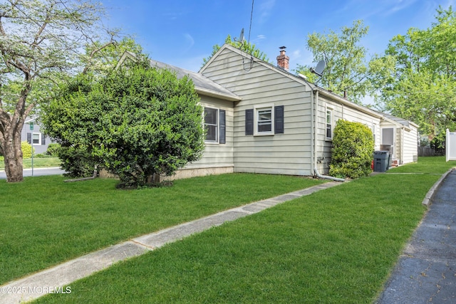 view of home's exterior featuring a chimney and a yard