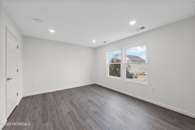 unfurnished room featuring wood finished floors, baseboards, and recessed lighting