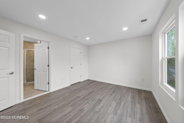 unfurnished bedroom with wood finished floors, recessed lighting, and baseboards