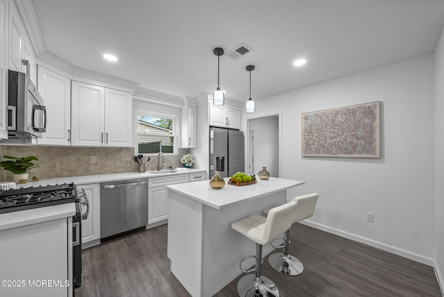 kitchen with stainless steel appliances, white cabinetry, dark wood-style flooring, light countertops, and decorative backsplash