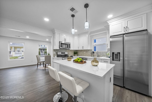kitchen featuring appliances with stainless steel finishes, white cabinetry, recessed lighting, tasteful backsplash, and light countertops