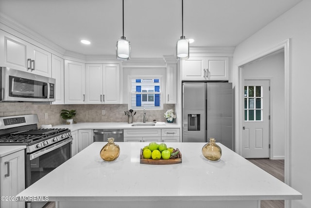 kitchen with appliances with stainless steel finishes, a sink, white cabinets, decorative backsplash, and recessed lighting