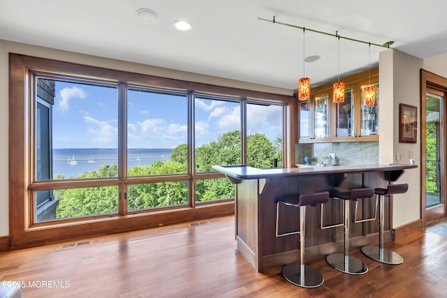 154 Ocean Blvd, Atlantic Highlands, NJ 07716 - indoor wet bar with wood finished floors, decorative light fixtures, a water view, decorative backsplash, and baseboards