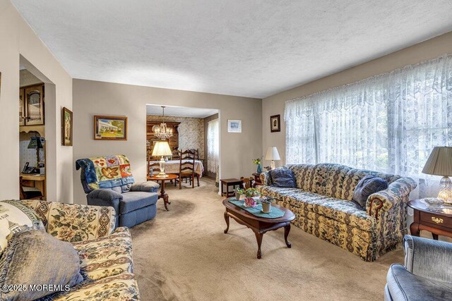 1601 Chestnut Ave, Ocean Twp, NJ 07712 - carpeted living area featuring a chandelier and a textured ceiling