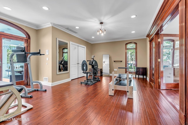 exercise room featuring baseboards, recessed lighting, ornamental molding, and hardwood / wood-style floors