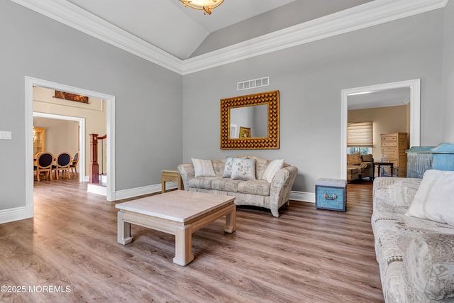 living area with light wood-type flooring, baseboards, ornamental molding, and high vaulted ceiling