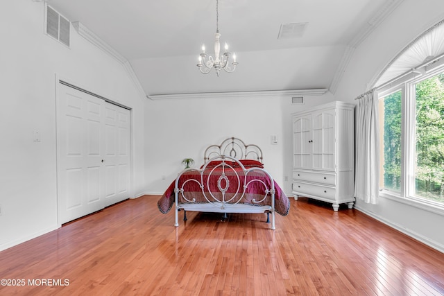 bedroom with a chandelier, multiple windows, lofted ceiling, crown molding, and light wood finished floors