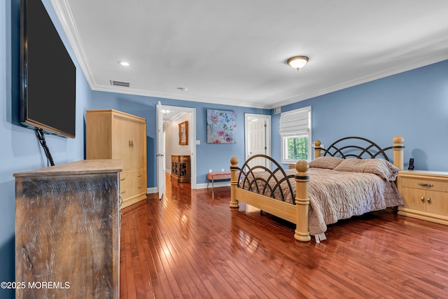 bedroom with wood-type flooring, crown molding, baseboards, and recessed lighting