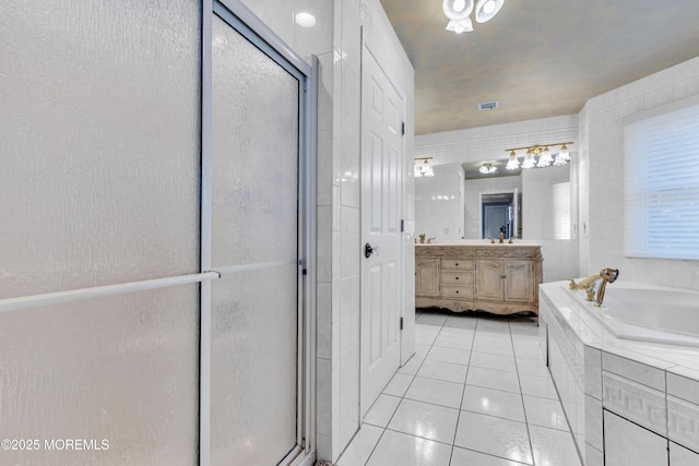 bathroom featuring tile patterned flooring, vanity, a shower stall, a bath, and tile walls
