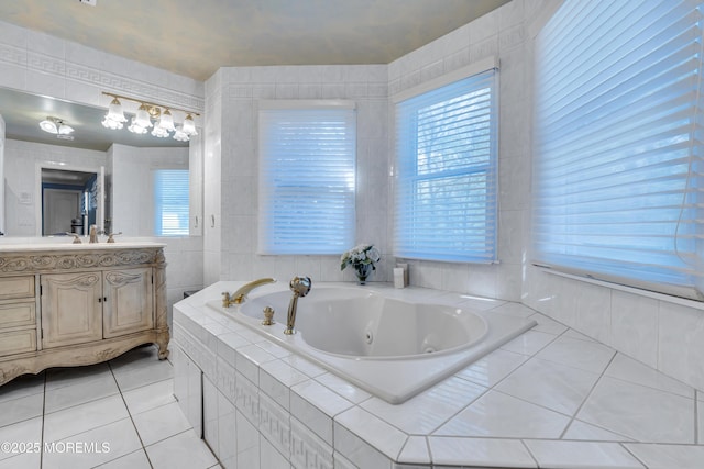 bathroom featuring tile patterned flooring, a jetted tub, vanity, and tile walls