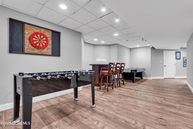 playroom featuring a dry bar, wood finished floors, baseboards, recessed lighting, and a paneled ceiling