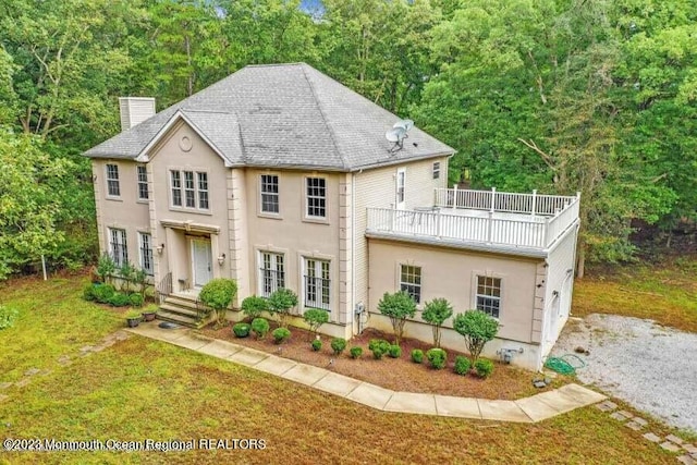 2557 Huckleberry Rd, Manchester, NJ 08759 - view of front of house with a chimney, a balcony, a front yard, and stucco siding