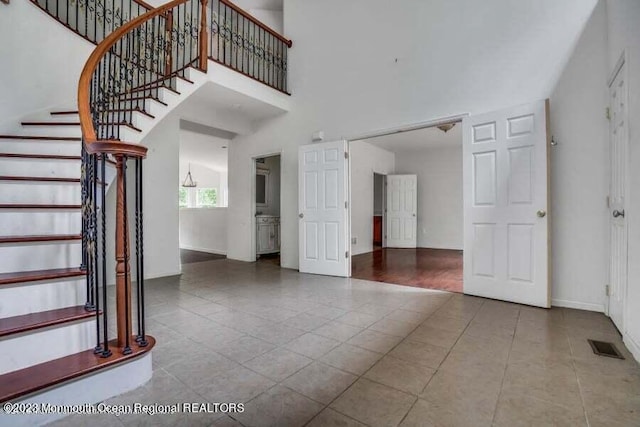2557 Huckleberry Rd, Manchester, NJ 08759 - stairs featuring tile patterned flooring, baseboards, and a high ceiling