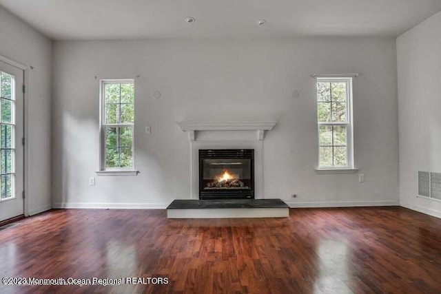 2557 Huckleberry Rd, Manchester, NJ 08759 - unfurnished living room with wood finished floors, a glass covered fireplace, healthy amount of natural light, and baseboards