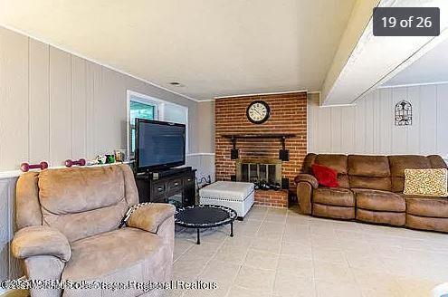living area with a brick fireplace and a decorative wall