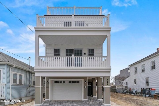 victorian home with a balcony, a garage, and driveway