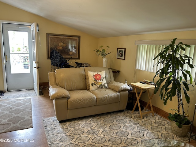 living room with vaulted ceiling, wood finished floors, and baseboards
