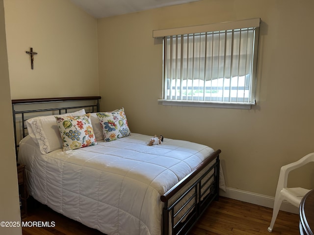 bedroom with wood finished floors and baseboards