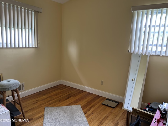 unfurnished room with wood finished floors and baseboards