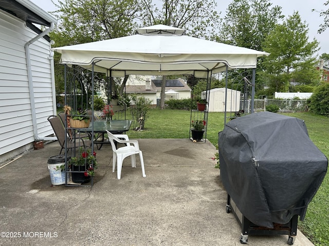 view of patio / terrace featuring a gazebo, a storage shed, outdoor dining space, a grill, and an outdoor structure