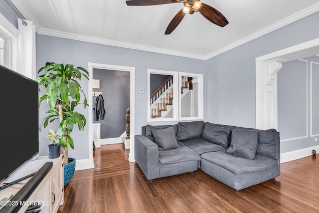 living room featuring ceiling fan, wood finished floors, ornamental molding, stairs, and baseboards