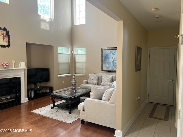 27 Stonehenge Ct, Jackson, NJ 08527 - living area with a fireplace with flush hearth, baseboards, wood finished floors, and a high ceiling
