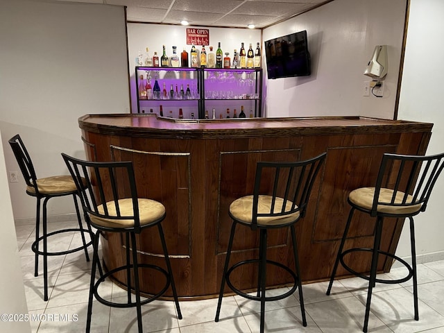 27 Stonehenge Ct, Jackson, NJ 08527 - indoor bar with light tile patterned floors, a paneled ceiling, and baseboards