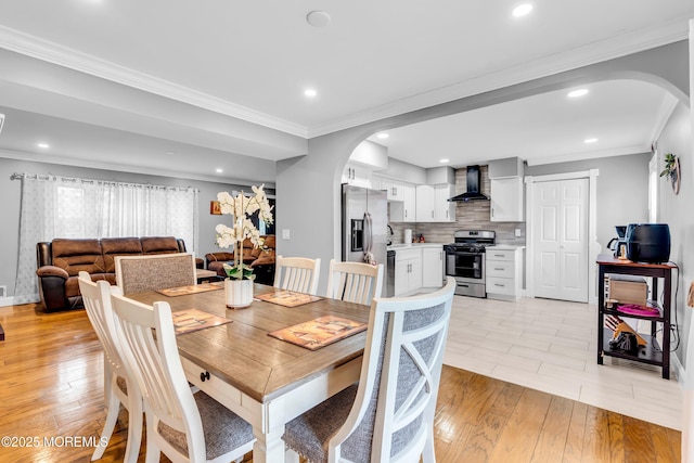 1012 Bismarck St, Toms River, NJ 08757 - dining area featuring arched walkways, light wood finished floors, recessed lighting, crown molding, and baseboards