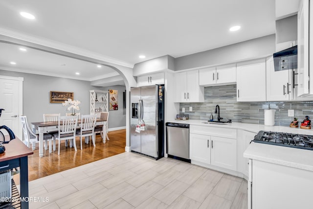 1012 Bismarck St, Toms River, NJ 08757 - kitchen featuring appliances with stainless steel finishes, a sink, light countertops, backsplash, and white cabinetry