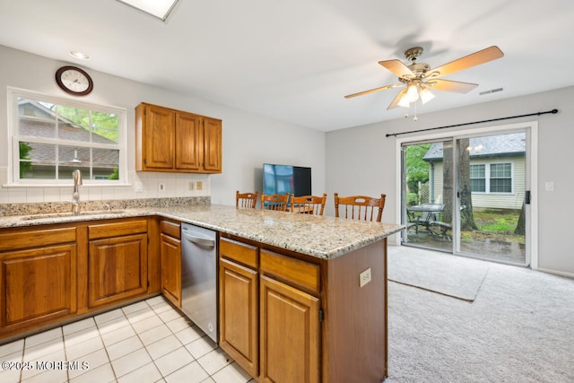 119 Morning Glory, Whiting, NJ 08759 - kitchen with a sink, stainless steel dishwasher, a peninsula, brown cabinets, and a ceiling fan