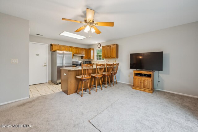 119 Morning Glory, Whiting, NJ 08759 - kitchen with ceiling fan, under cabinet range hood, stainless steel appliances, light carpet, and brown cabinets