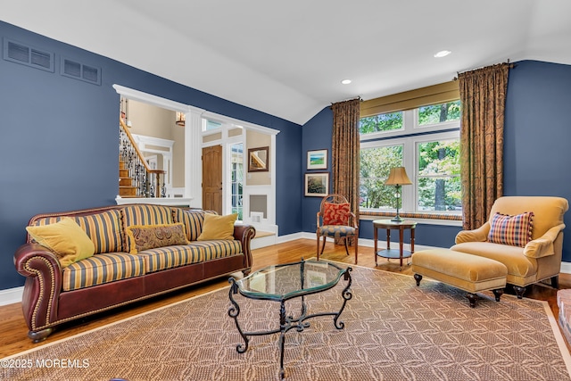 7 Seagull Ln, Lincroft, NJ 07738 - living area featuring vaulted ceiling, wood finished floors, baseboards, stairway, and decorative columns