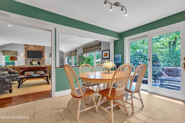 7 Seagull Ln, Lincroft, NJ 07738 - dining space featuring light tile patterned flooring, a stone fireplace, and lofted ceiling