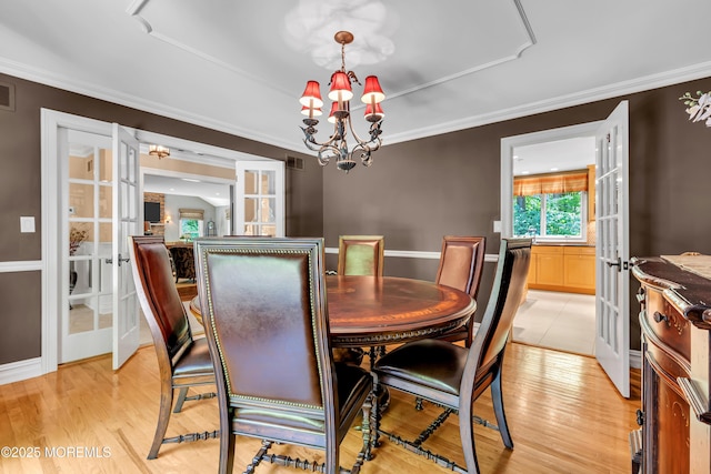 7 Seagull Ln, Lincroft, NJ 07738 - dining room featuring french doors, a chandelier, light wood-type flooring, crown molding, and baseboards