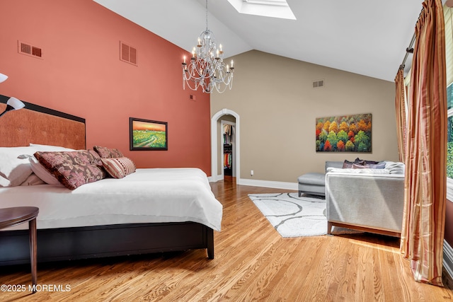 7 Seagull Ln, Lincroft, NJ 07738 - bedroom with arched walkways, a skylight, high vaulted ceiling, a chandelier, and light wood-type flooring
