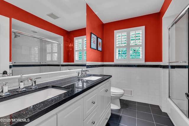 7 Seagull Ln, Lincroft, NJ 07738 - bathroom featuring tile walls, tile patterned floors, toilet, a shower with shower door, and a wainscoted wall