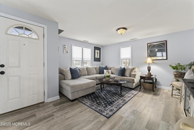 living room with light wood-style flooring and baseboards