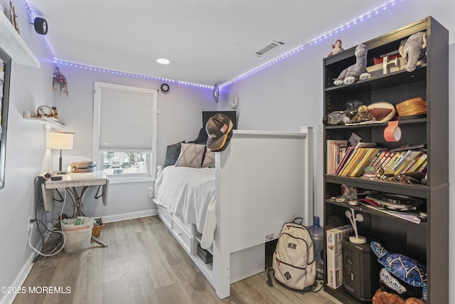 bedroom with wood finished floors and baseboards