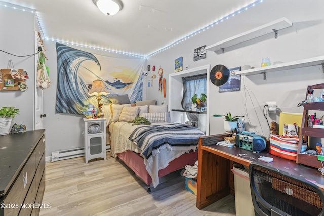 bedroom with light wood-style floors and baseboard heating