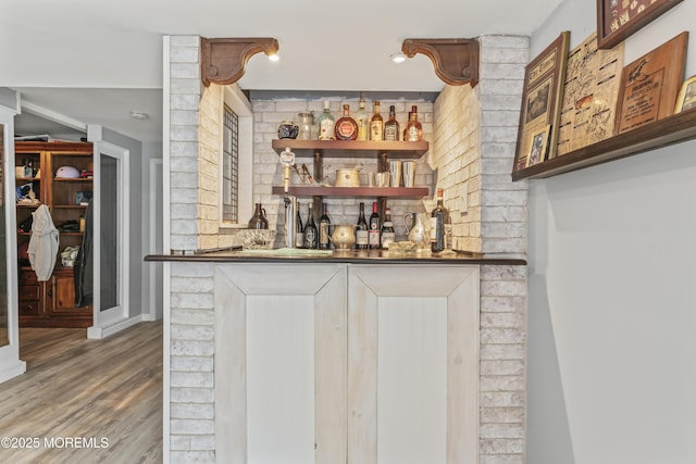 indoor dry bar featuring wood finished floors